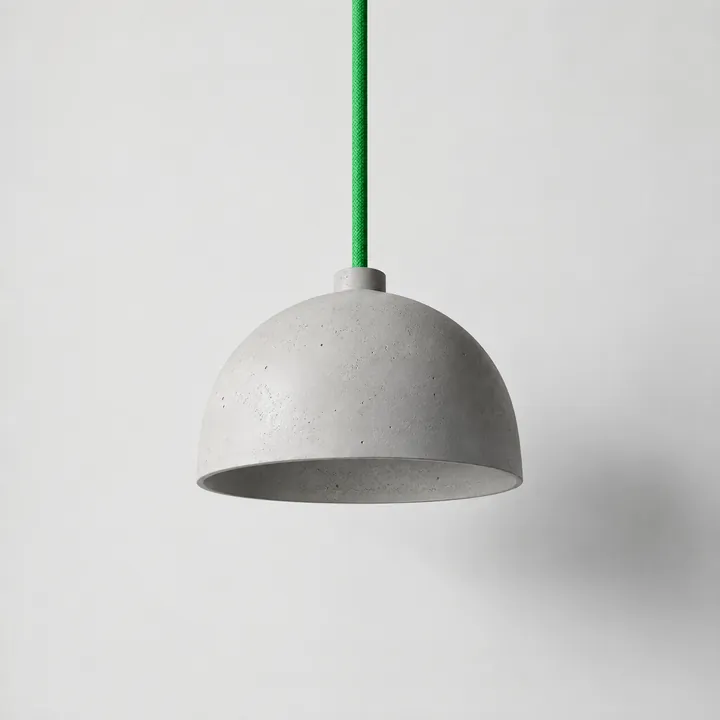 Pendant lamp in pale cast concrete on a green braided cable
